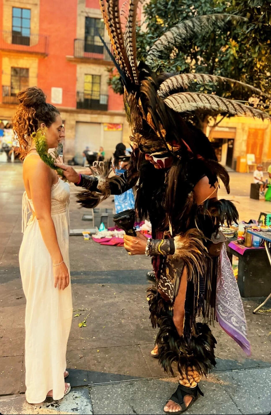 A visitor receiving a traditional 'limpia' (spiritual cleansing) from an indigenous practitioner in the historic center of Mexico City, a powerful cultural highlight of our private tours.
