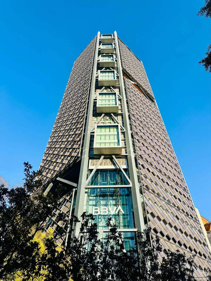 Low-angle view of the iconic BBVA skyscraper against, highlighting the modern architectural skyline of Mexico City's financial district.