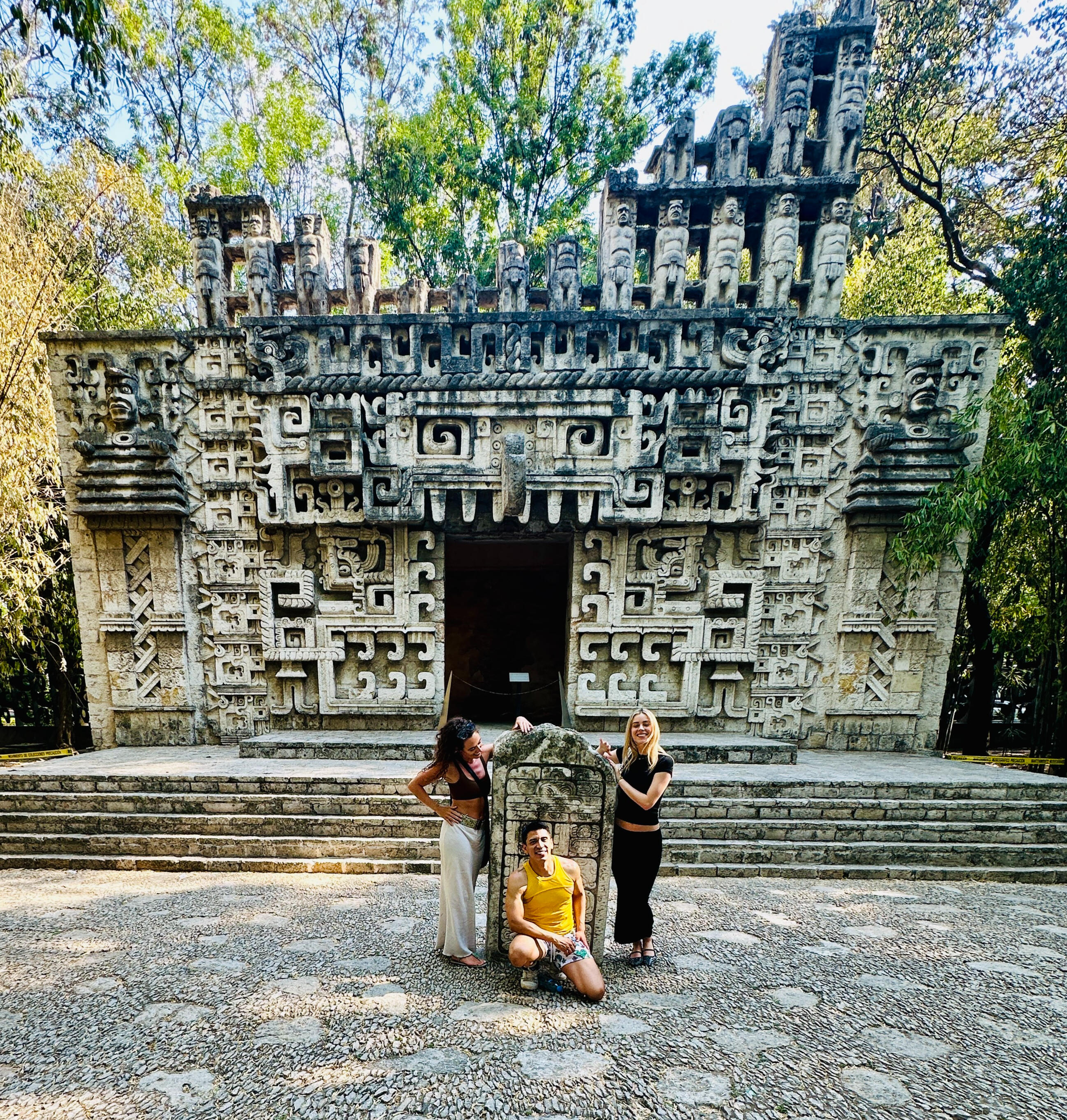Erik and friends posing in front of the impressive carved stone facade during a curated private tour at Mexico City's Anthropology Museum