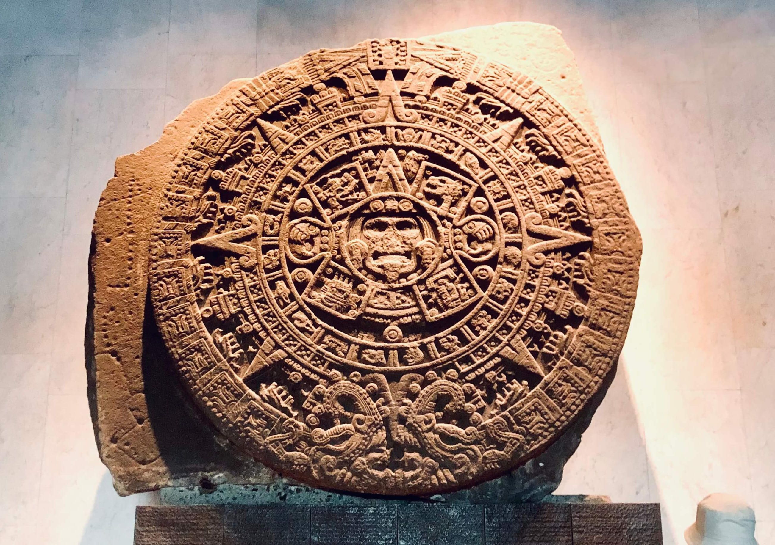 Close-up detail of the ancient Aztec Sun Stone (Piedra del Sol) exhibited in a museum, highlighting the rich cultural heritage featured in our curated Mexico City tours.