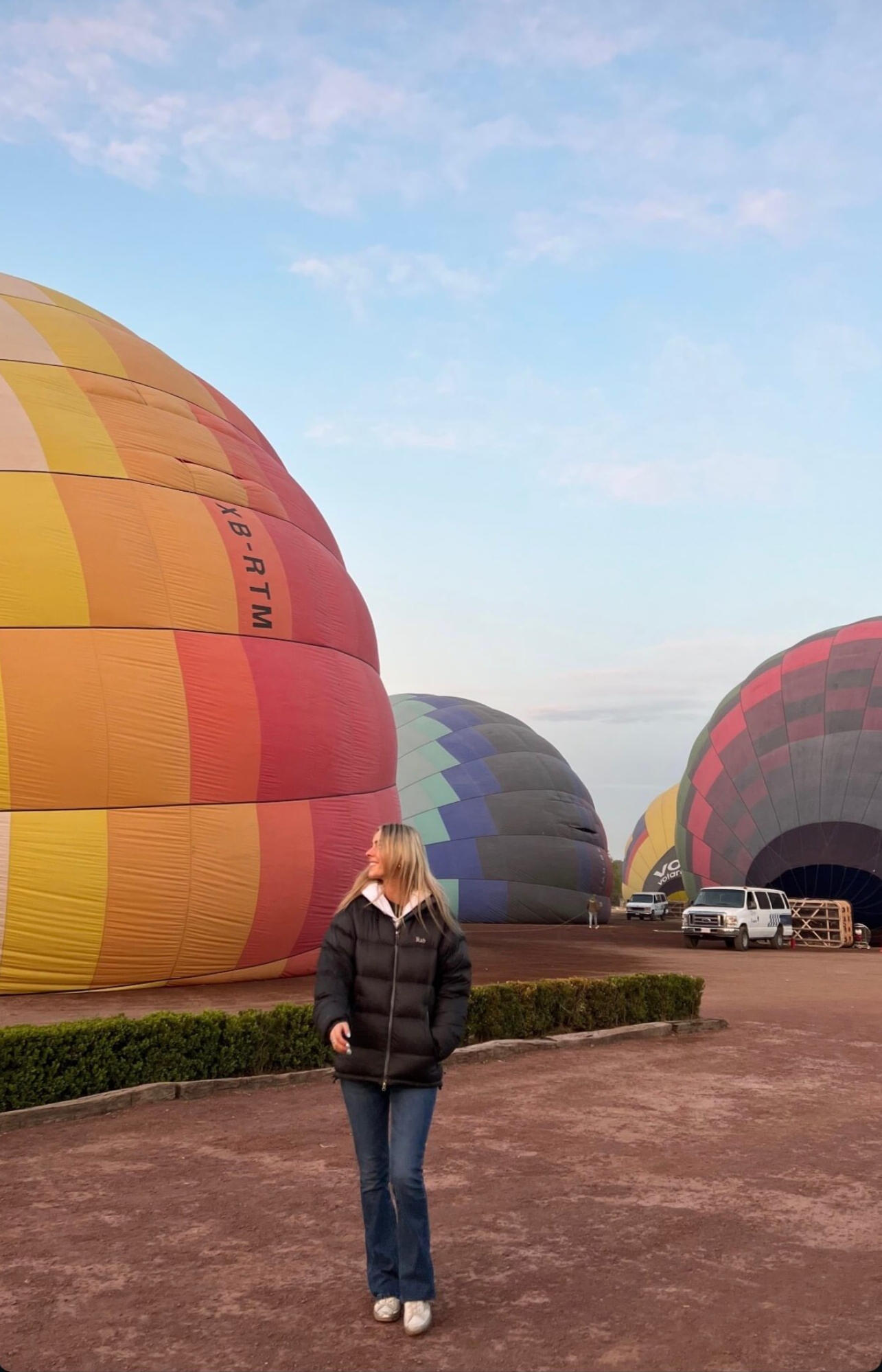 A visitor standing before colorful hot air balloons in Mexico City, showcasing an adventurous and scenic highlight of our exclusive travel experiences.